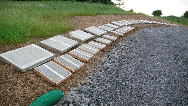 A series of cement panels arranged on the ground outside.