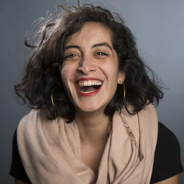 Ala Tannir headshot; woman laughing wearing scarf.