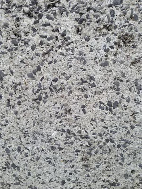 A detail of concrete with black aggregate.